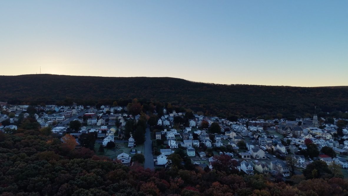 Aerial view of Jim Thorpe at dusk, town lights below the ridge